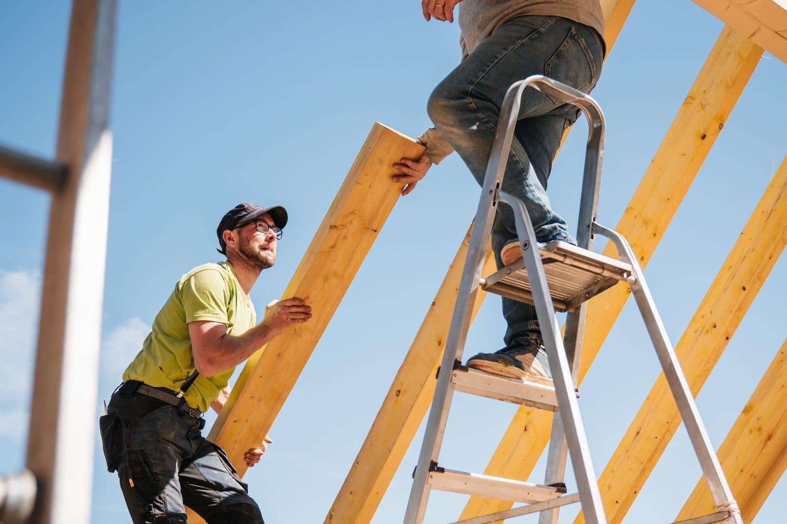 Deux ouvriers montent une charpente sur un chantier