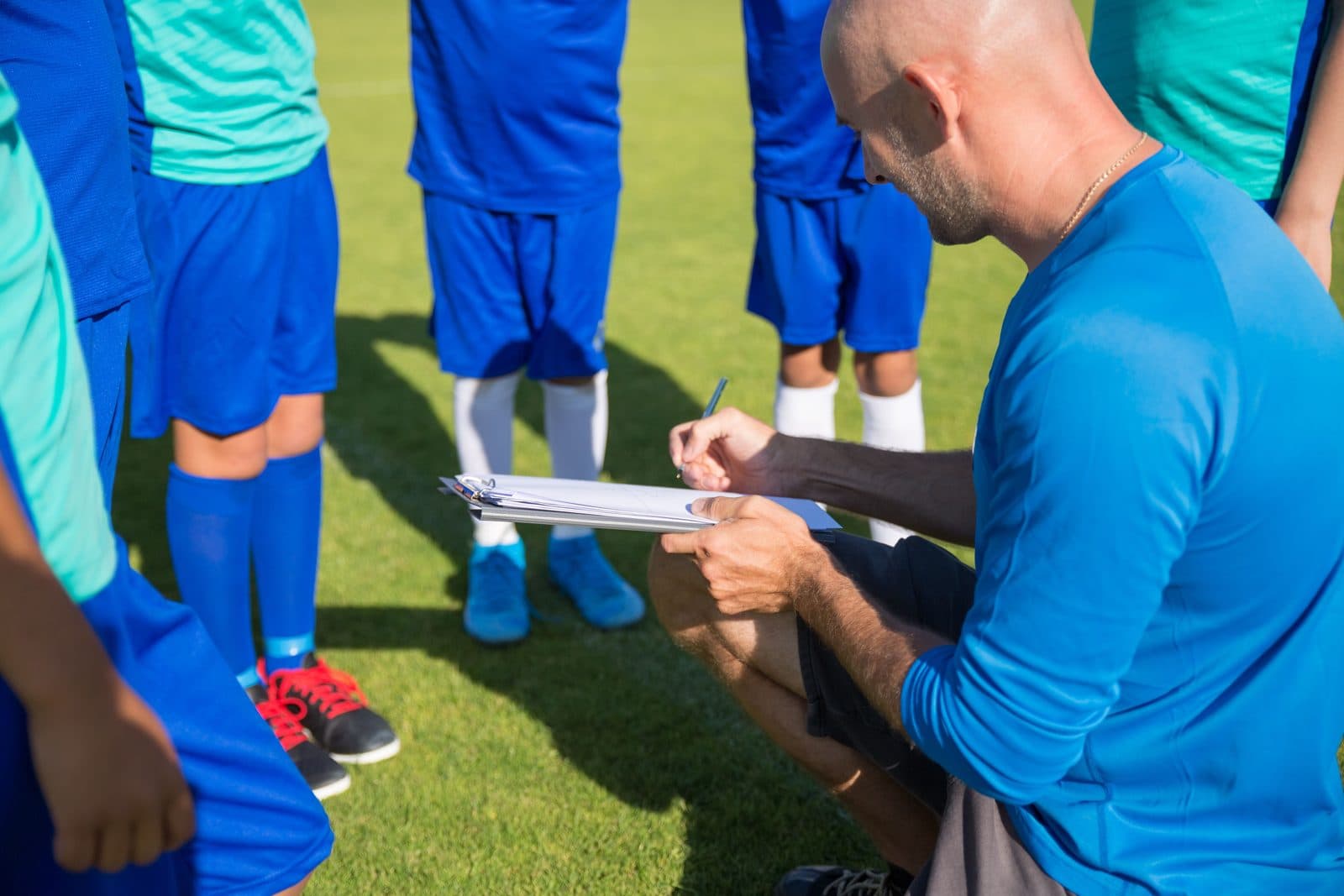 Un entraîneur prend des notes devant son équipe